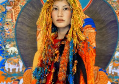 Fashion photo of woman wearing colourful wool wig and dress in front of colourful background